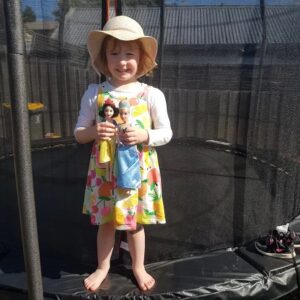 A Girl Stand On Trampoline With Doll