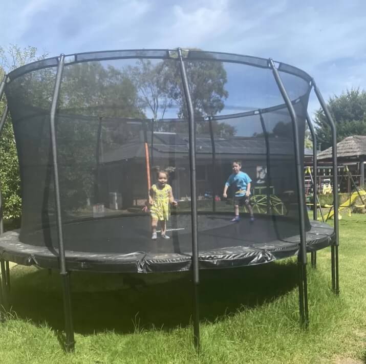 Two Small Kids Play In Trampoline
